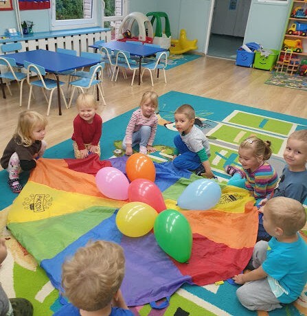 Zabawy Krasnoludków z chustą animacyjną w sali i ogrodzie przedszkolnym
