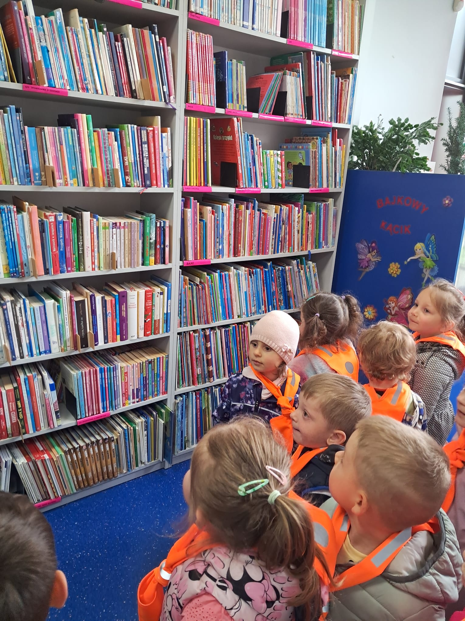 Maluszki wybrały się na wycieczkę do pobliskiej biblioteki, z ciekawością obserwując nowe miejsce i osoby tam pracujące.      